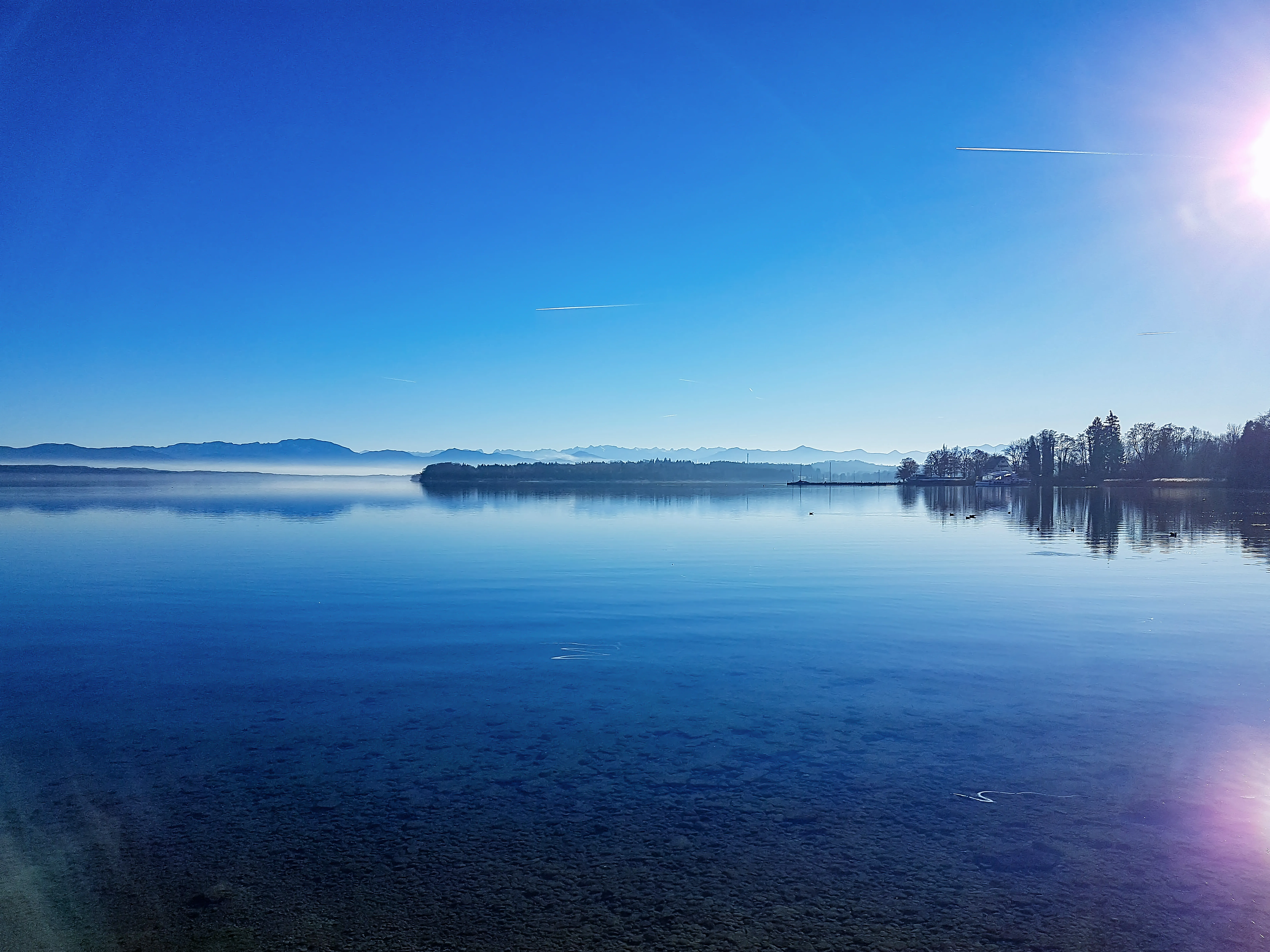 Winterliche Uferlandschaft am Starnberger See unter hellem Himmel